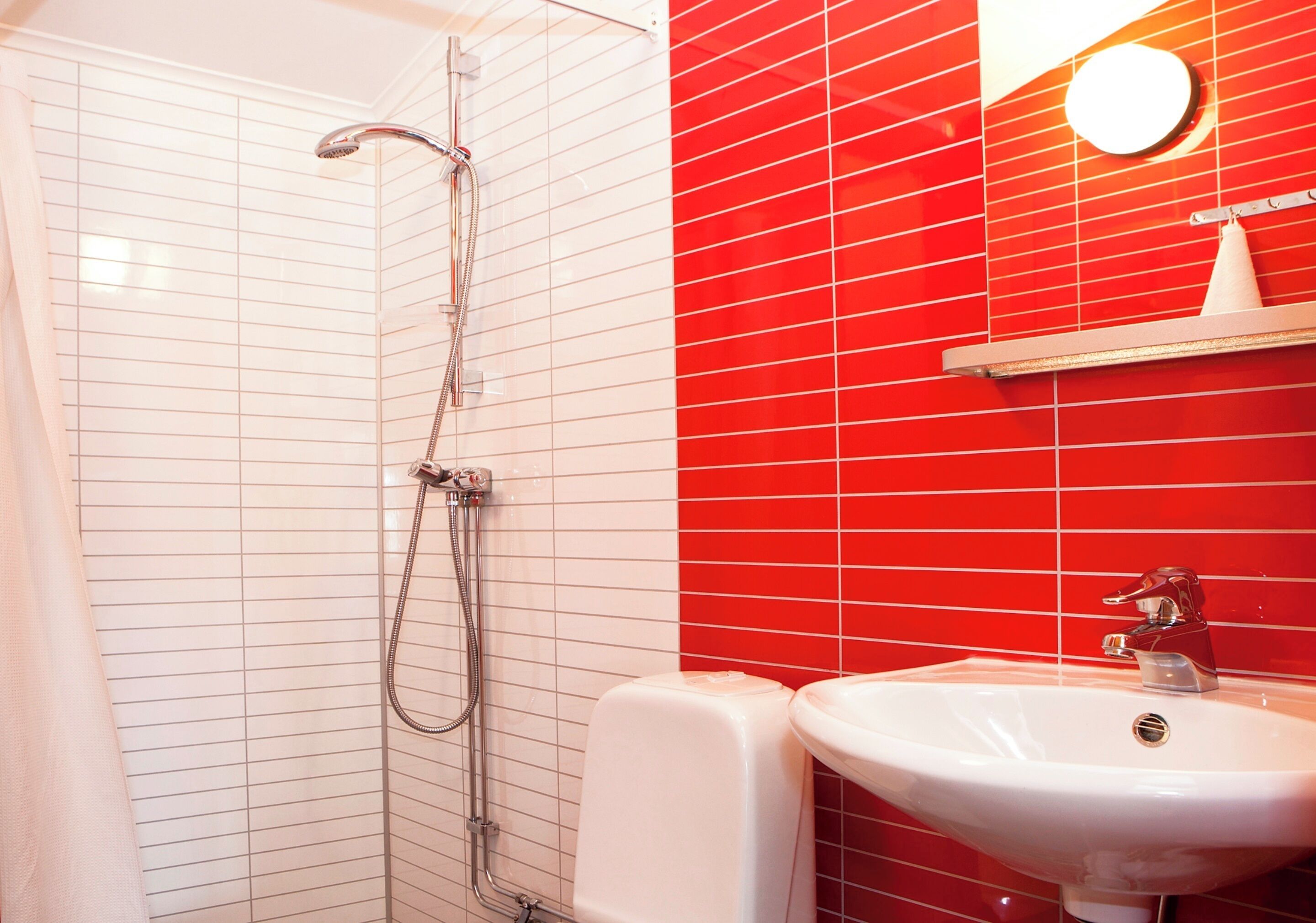 A bathroom with a shower, a sink, and a mirror.