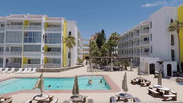 Relax by the resort pool surrounded by lounge chairs and umbrellas.