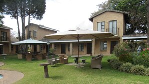 A courtyard with outdoor seating, a pool, and a building with a brick facade. - Hoyohoyo Chartwell Lodge (Chartwell)