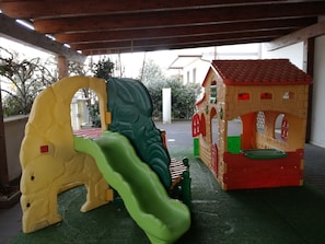 A children's play area with a slide and a small house structure. - Albergo Ristorante Protti (Cattolica)