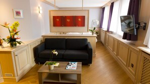 Una sala de estar moderna con un sofá, una mesa de centro y un televisor de pantalla plana montado en la pared.