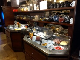 Zona de buffet con diferentes alimentos y condimentos.