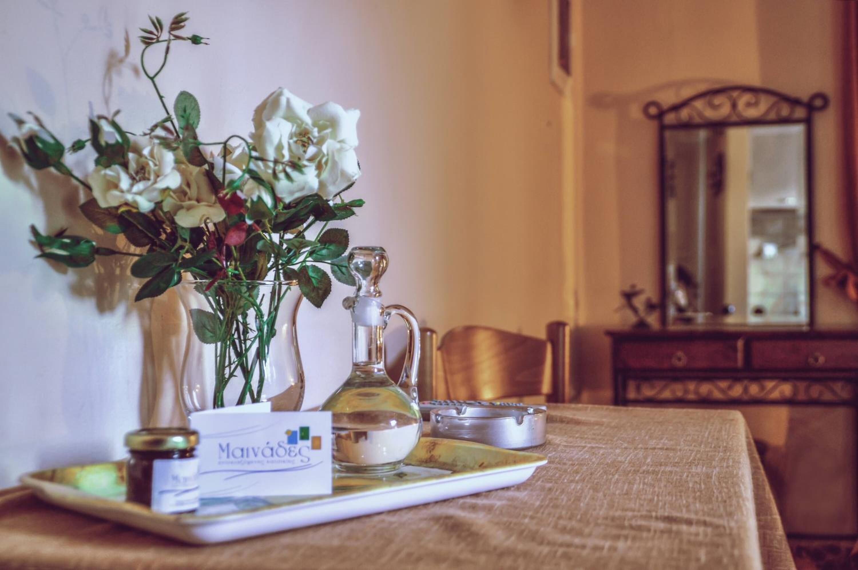 Une table avec un marque-place, une bouteille en verre et un plateau sur lequel se trouvent un pot et une boîte.