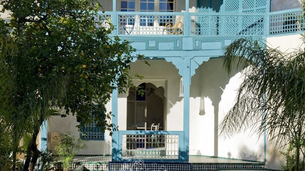 Un bâtiment traditionnel avec un canal d’eau devant, un balcon et une porte dotée d’une fenêtre.