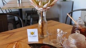 En morgenmadstallerken med ristet brød, æg og pølser på et bord hos NEIGHBOURHOOD Cafe.