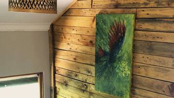 Una habitación con paredes de madera, una ventana y un cuadro.