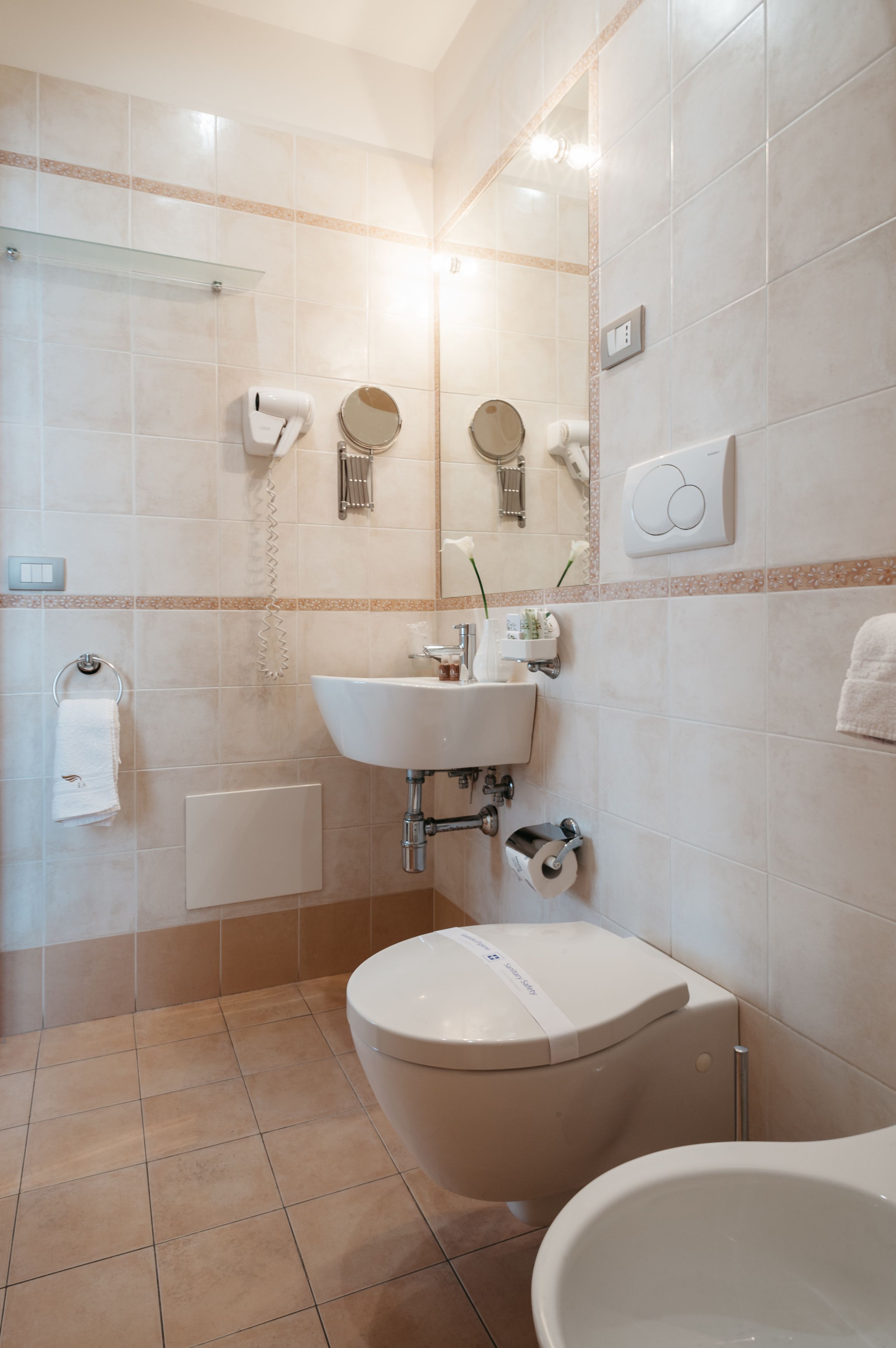 Une salle de bain comprenant des toilettes, un lavabo et un espace douche.
