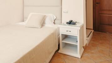A bedroom with a bed, bedside table, and a wardrobe.