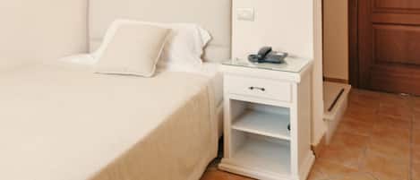 Une chambre à coucher avec un lit, une table de chevet et une armoire.