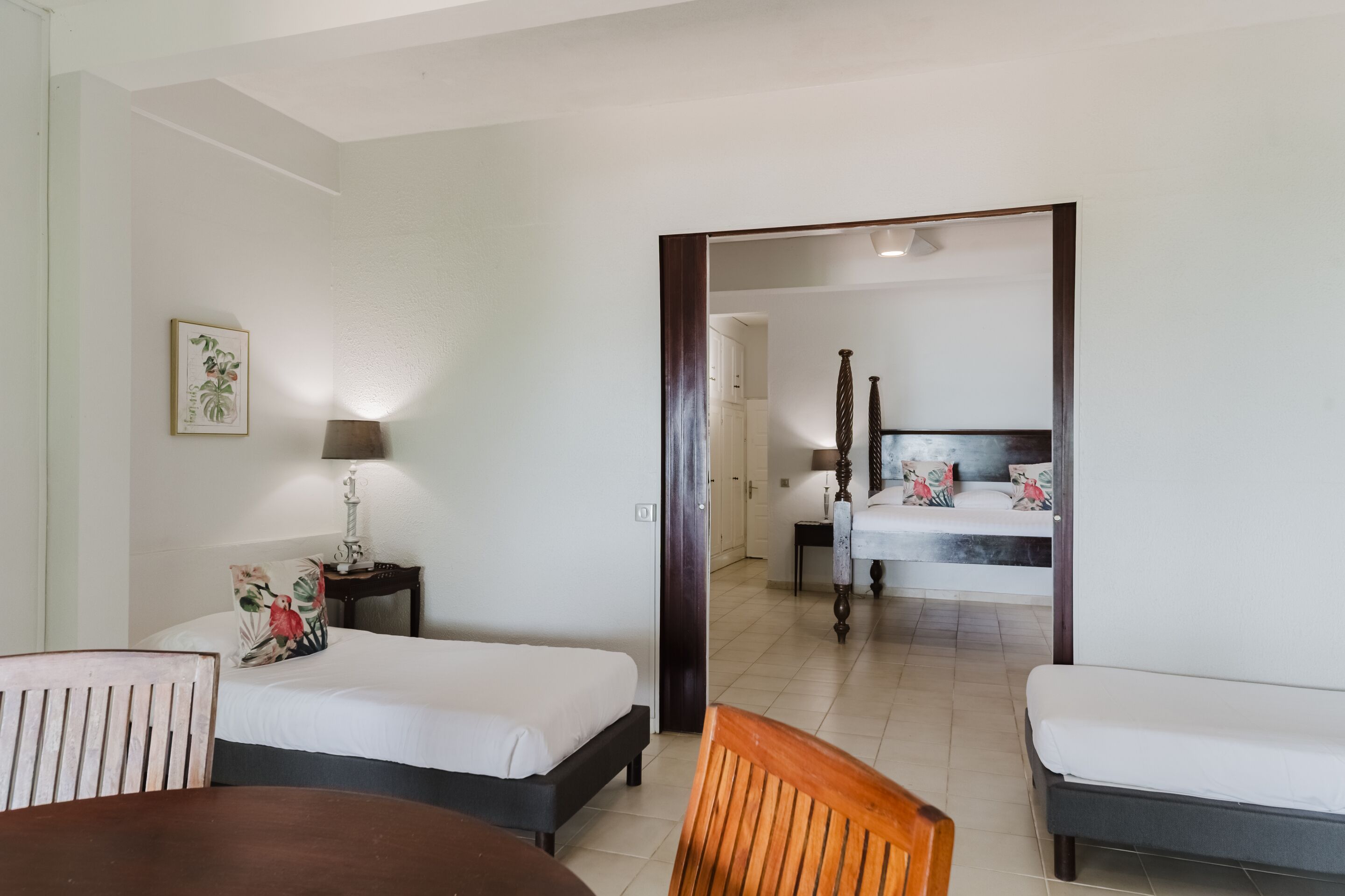 Una habitación de hotel con dos camas, una mesa de comedor y una silla.