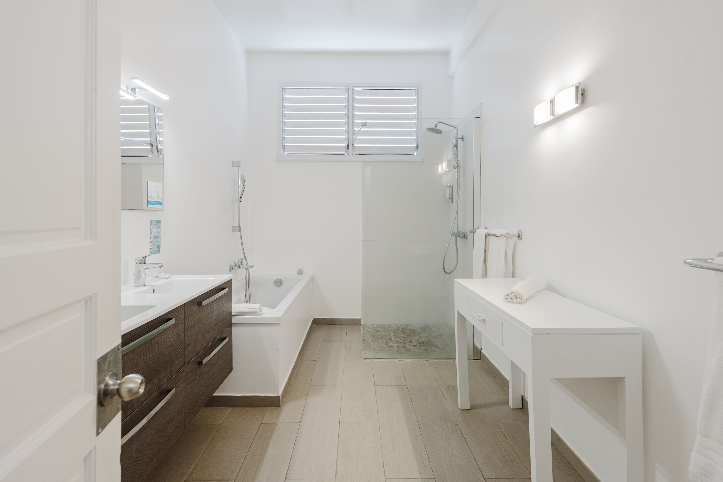 A modern bathroom with a bathtub, a shower, a vanity with a mirror, and a toilet.