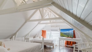 A spacious attic bedroom with two beds, a desk, and a TV. - Hôtel Frégate Bleue (Le Francois)