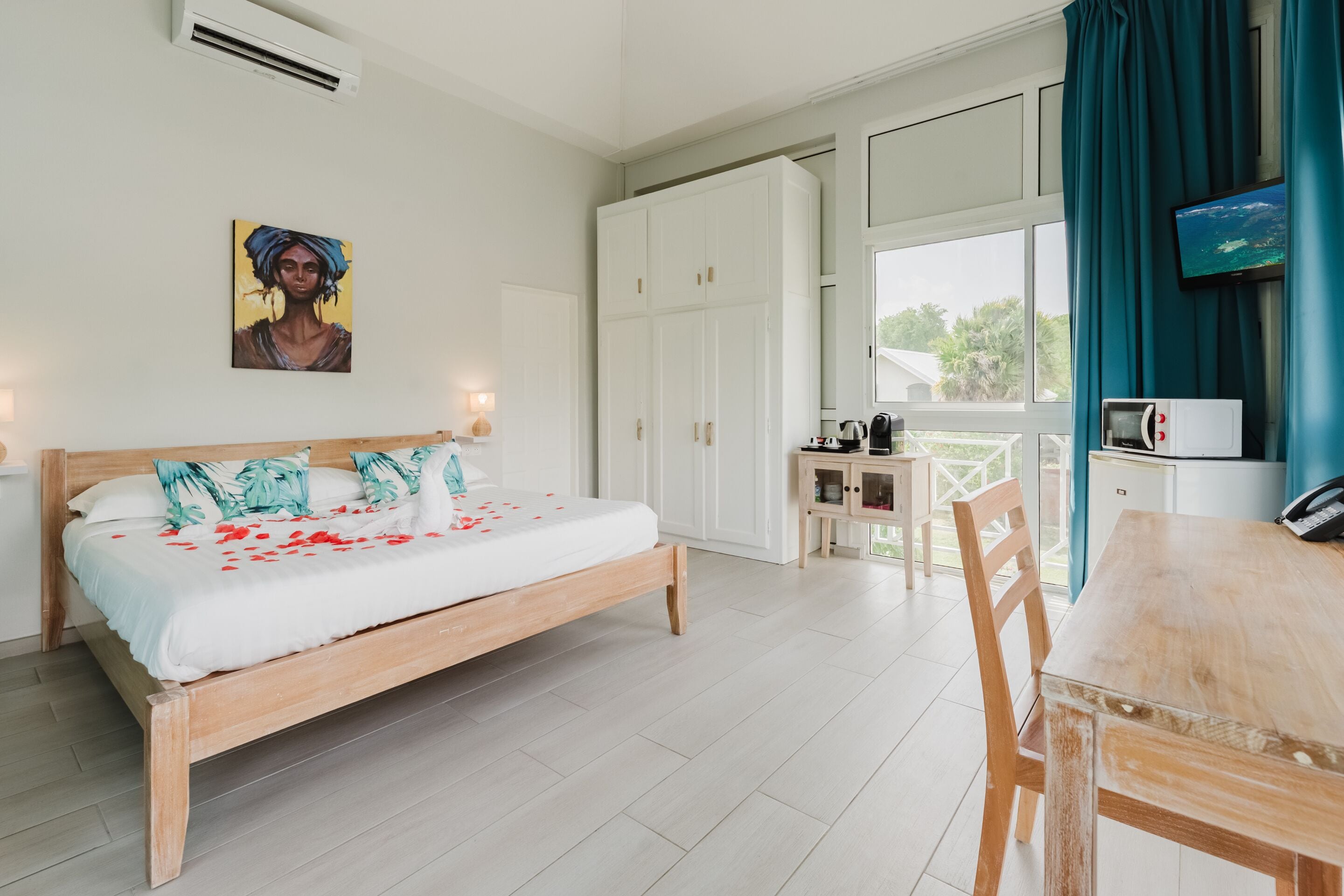 Un dormitorio con una cama, un escritorio y un televisor.