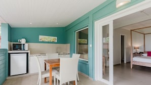 A compact hotel room with a kitchenette, a dining area, and a bedroom. - Hôtel Frégate Bleue (Le Francois)