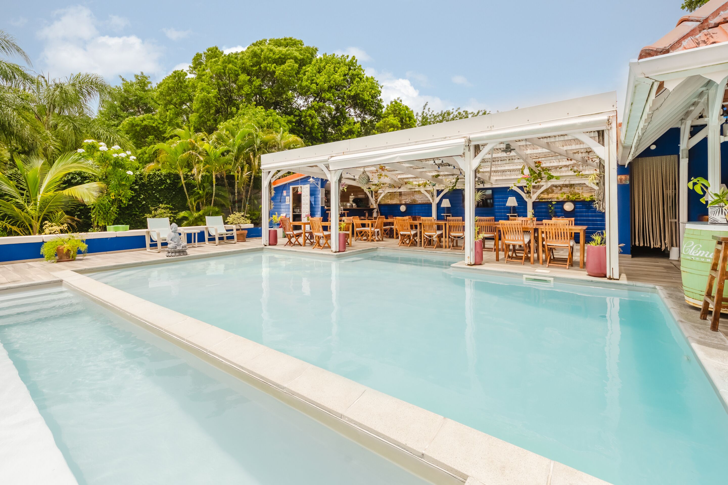 Una piscina al aire libre, sillones reclinables de piscina