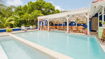 Una piscina al aire libre, sillones reclinables de piscina