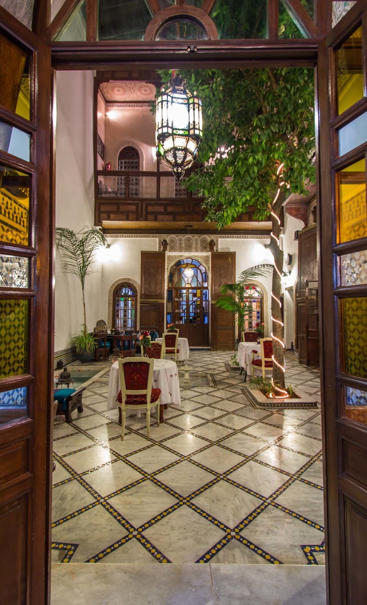 A traditional interior with a tiled floor, wooden furniture, and a hanging lantern.