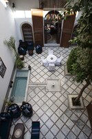 Un patio con piscina, zona de estar y una puerta que da a un espacio interior.