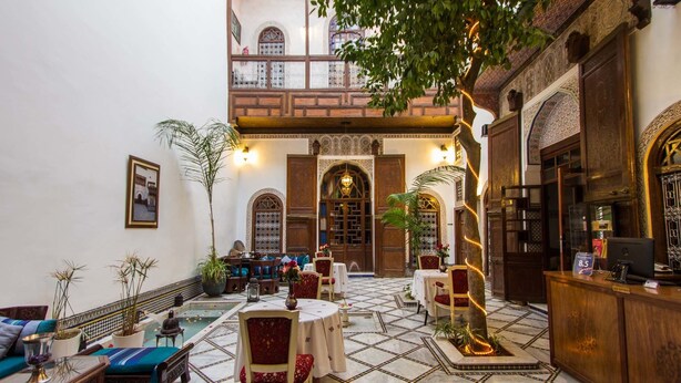 Ein geräumiger Innenhof mit Pool, Sitzbereichen und einer Bar.