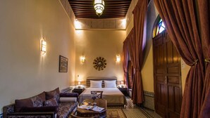 Ein Hotelzimmer mit Bett, Sofa, kleinem Tisch und einer Wanddekoration.