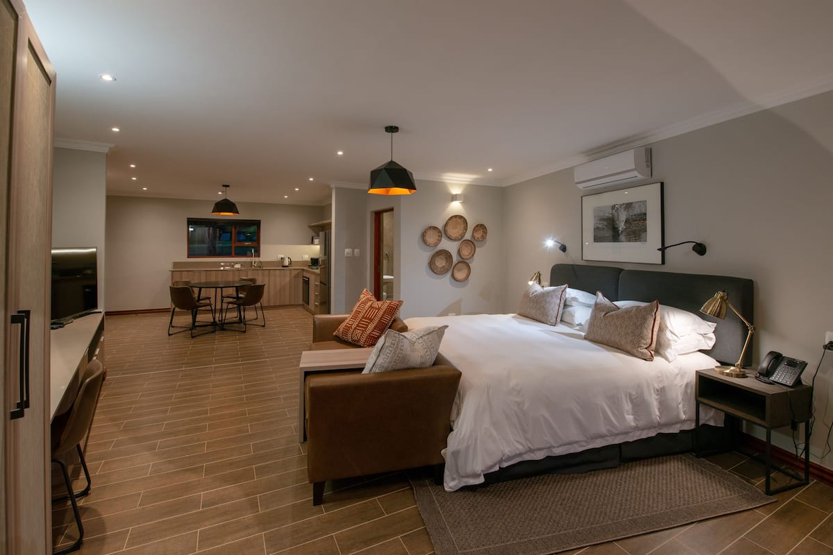 Une chambre moderne avec un grand lit, un bureau et un coin repas.