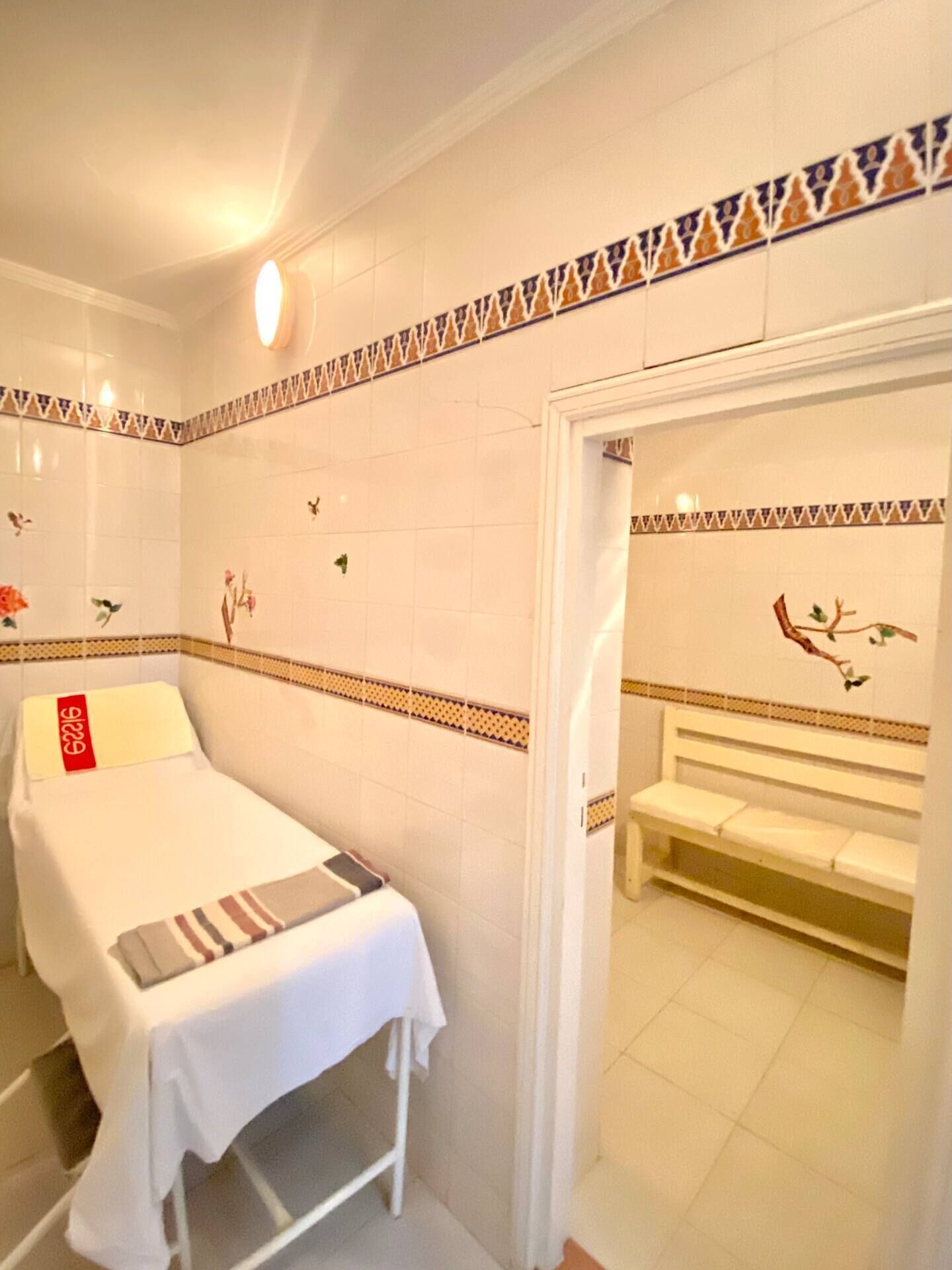 Ein Hotelzimmer mit einem Bett, einer Sitzbank und einer Tür zu einem Badezimmer.