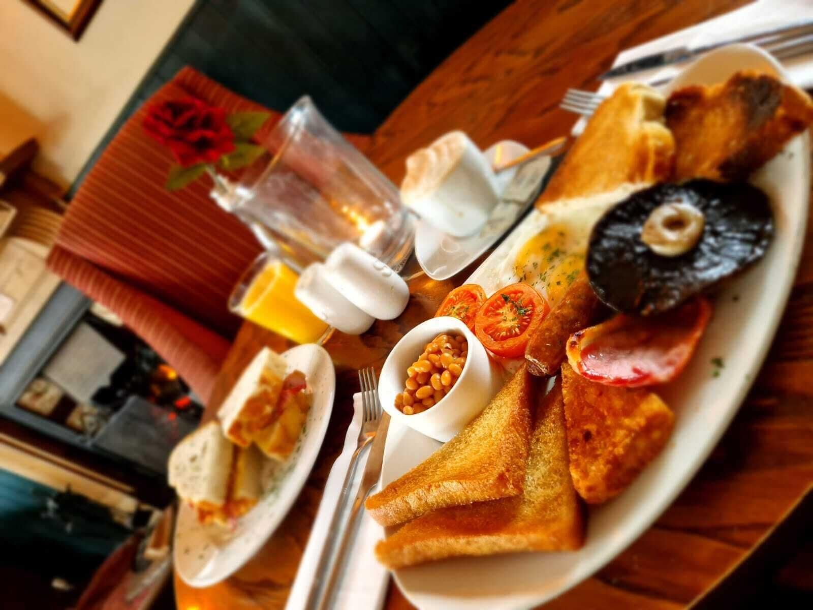 Un piatto da colazione con pane tostato, uova, pomodori e fagioli.