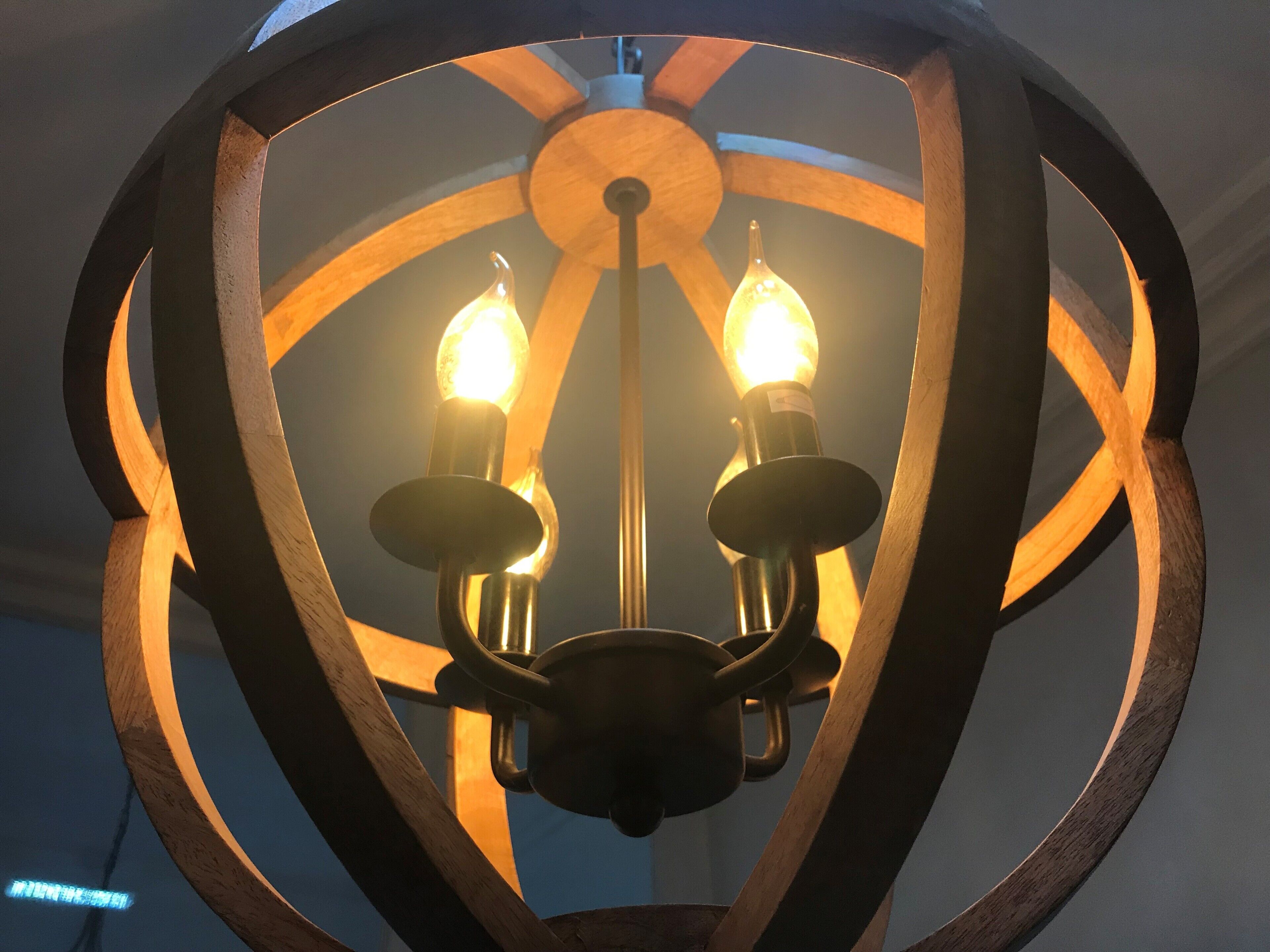A chandelier with a wooden frame and two light bulbs.