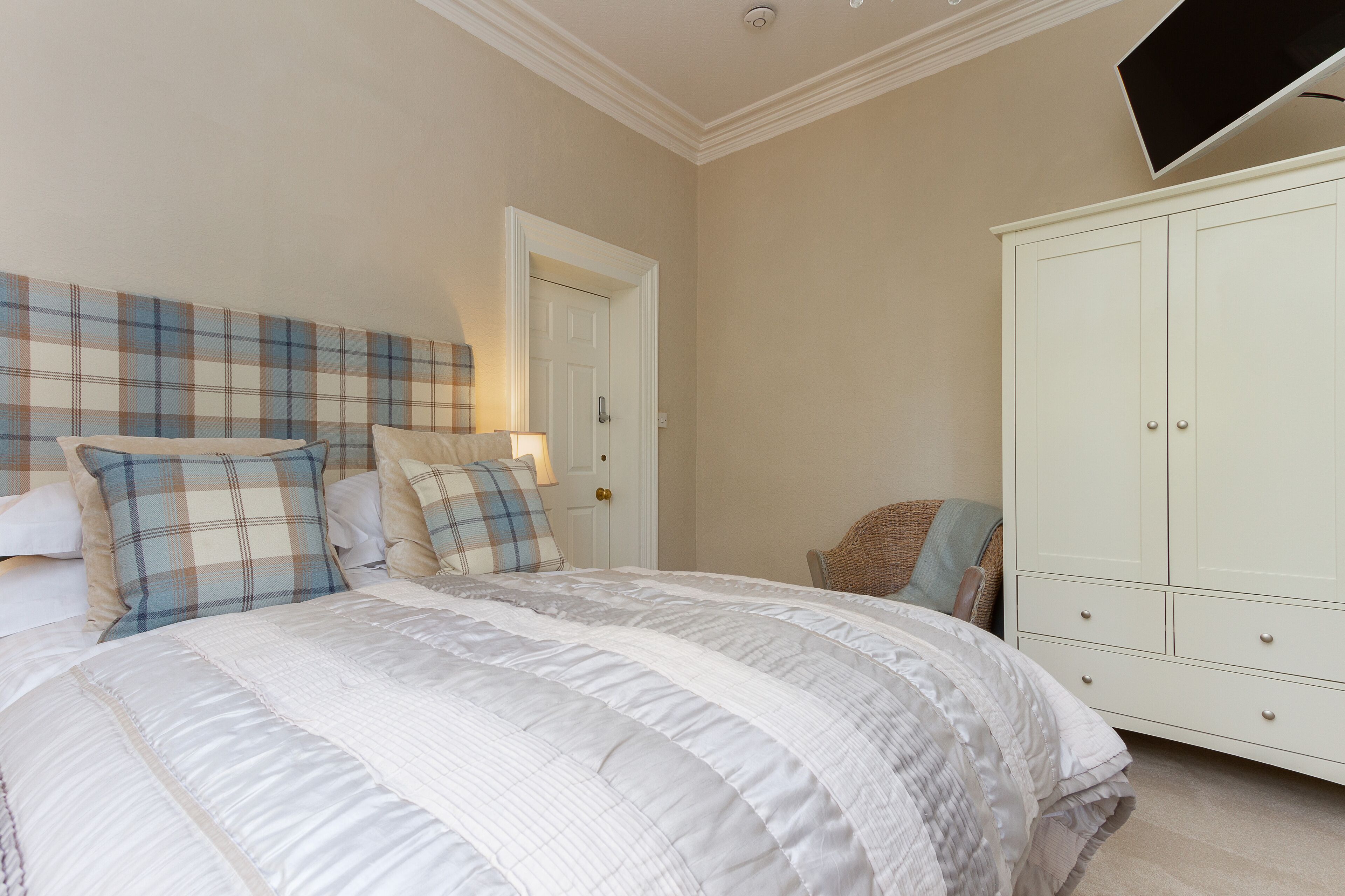 Une chambre à coucher avec un grand lit, une armoire et une porte.