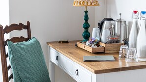 A wooden desk with a lamp, a coffee maker, and a kettle. - Three Tuns (Helston)