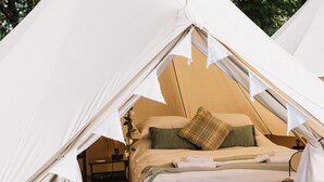 A tent with a bed, pillows, and a nightstand. - Three Tuns (Helston)