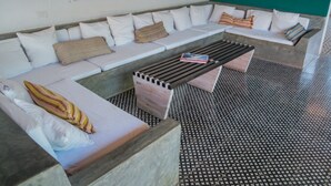 A modern lounge area with a sectional sofa, a wooden coffee table, and patterned cushions. - Los Patios Hotel (Granada)