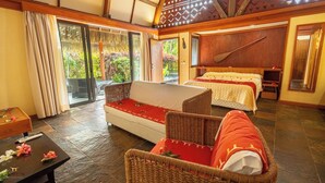 Habitación de hotel con sofá, dos camas, una pala de madera y vistas a zonas verdes.
