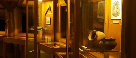A museum exhibit with glass display cases containing pottery and artifacts.