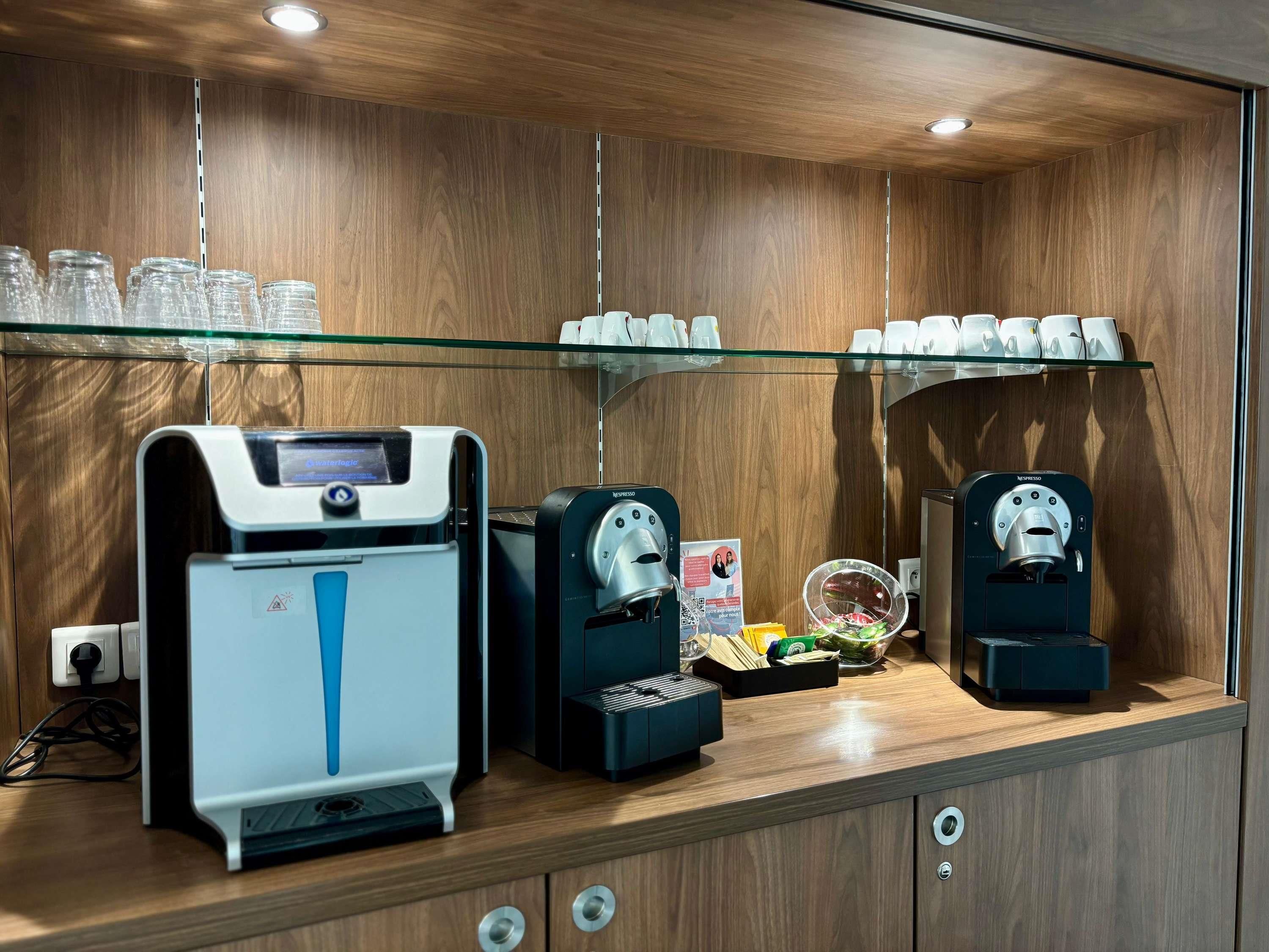 A coffee station with a water dispenser, a coffee machine, and a Nespresso machine.