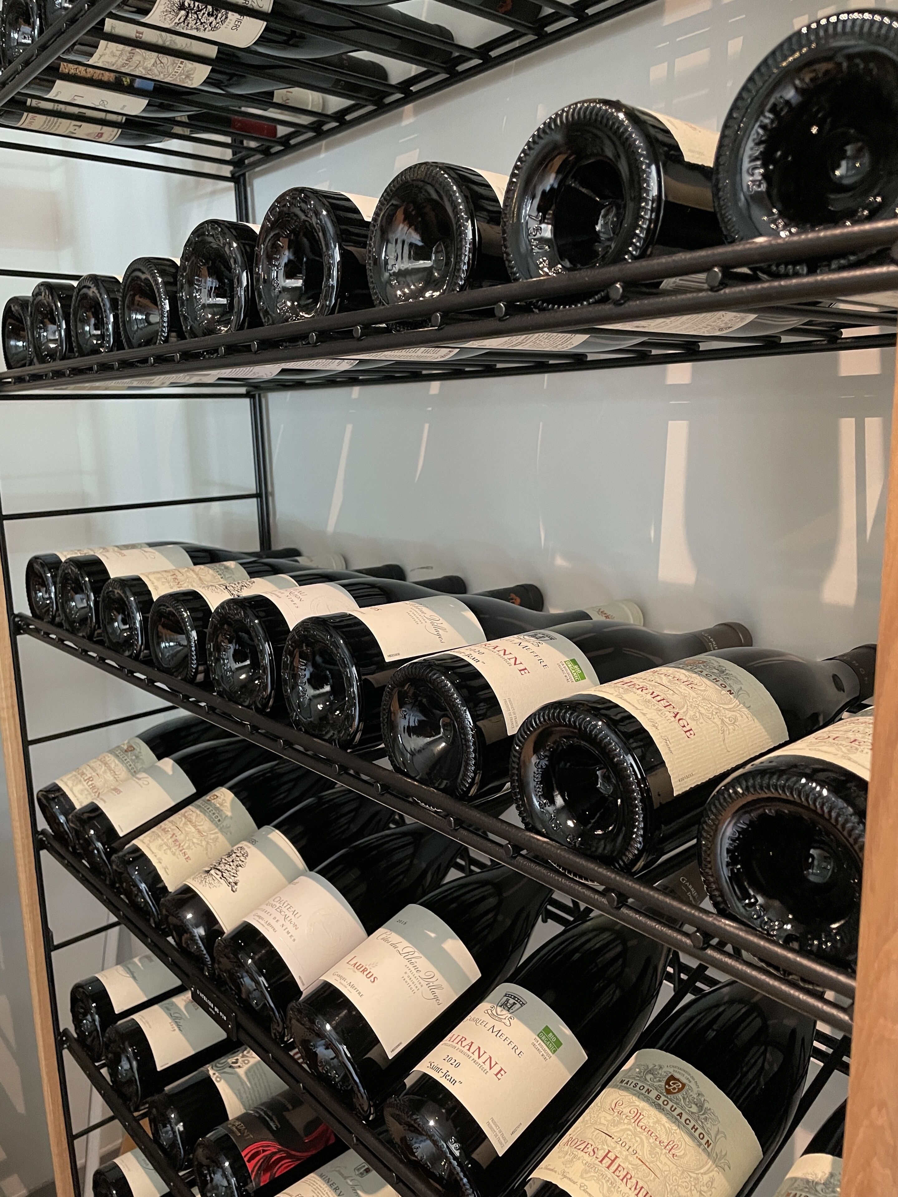 A wine rack with multiple bottles of wine, each with labels visible.