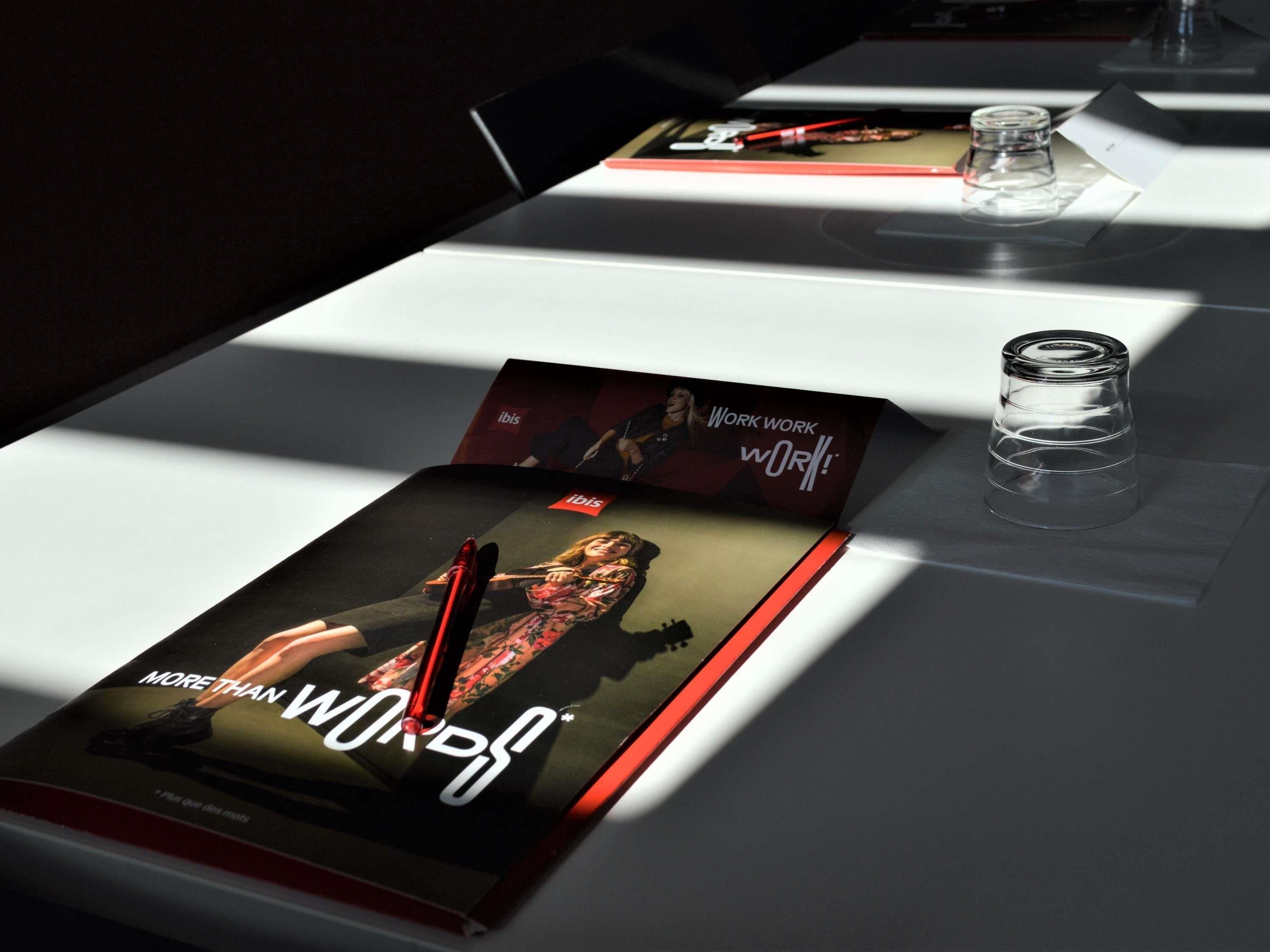 A table with a magazine, a glass, and a pen.