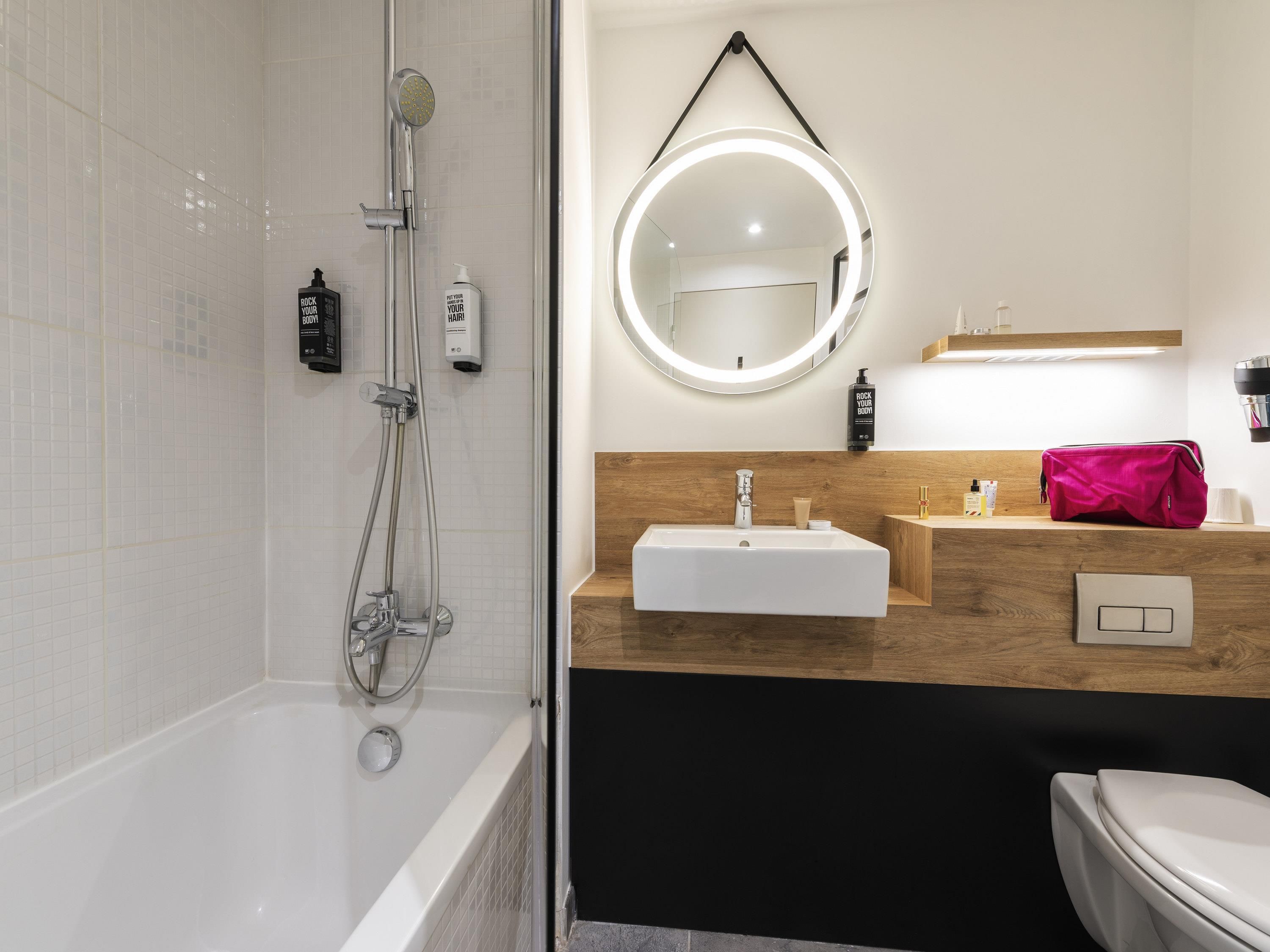A modern bathroom with a shower, a sink, and a toilet.