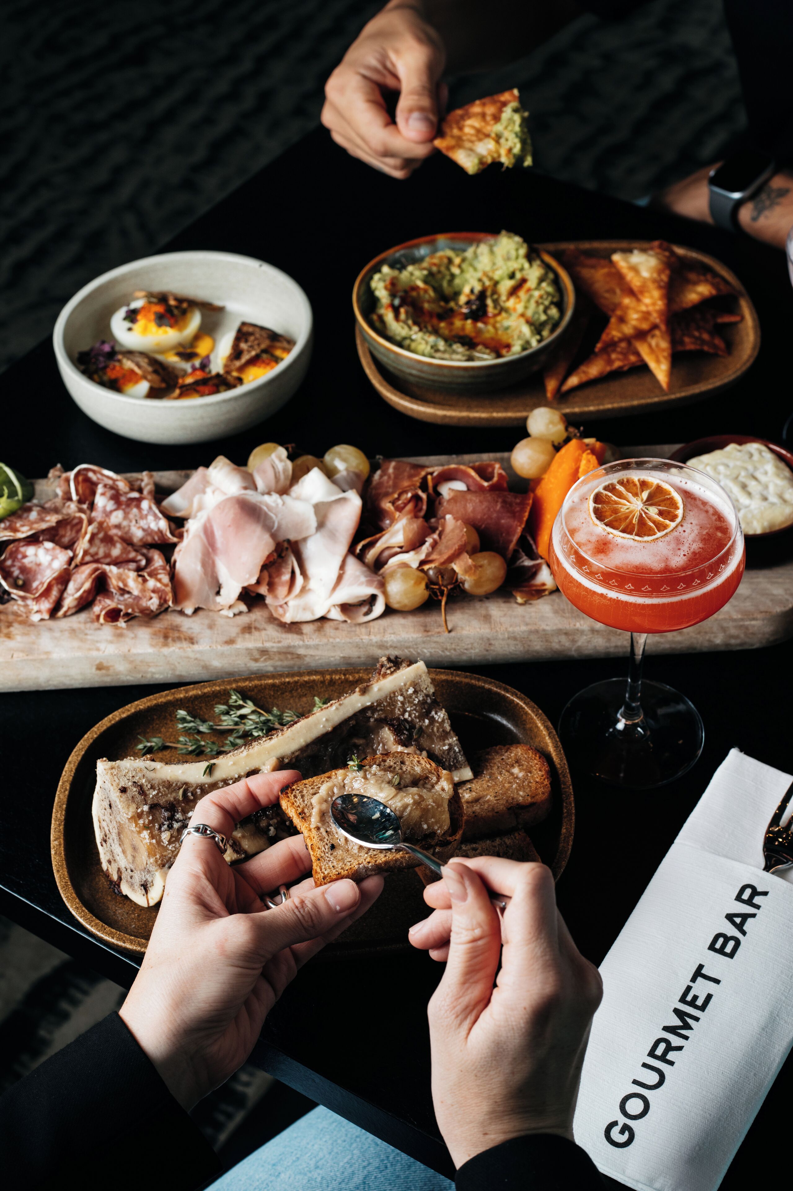 A dining table with various food items and a drink.