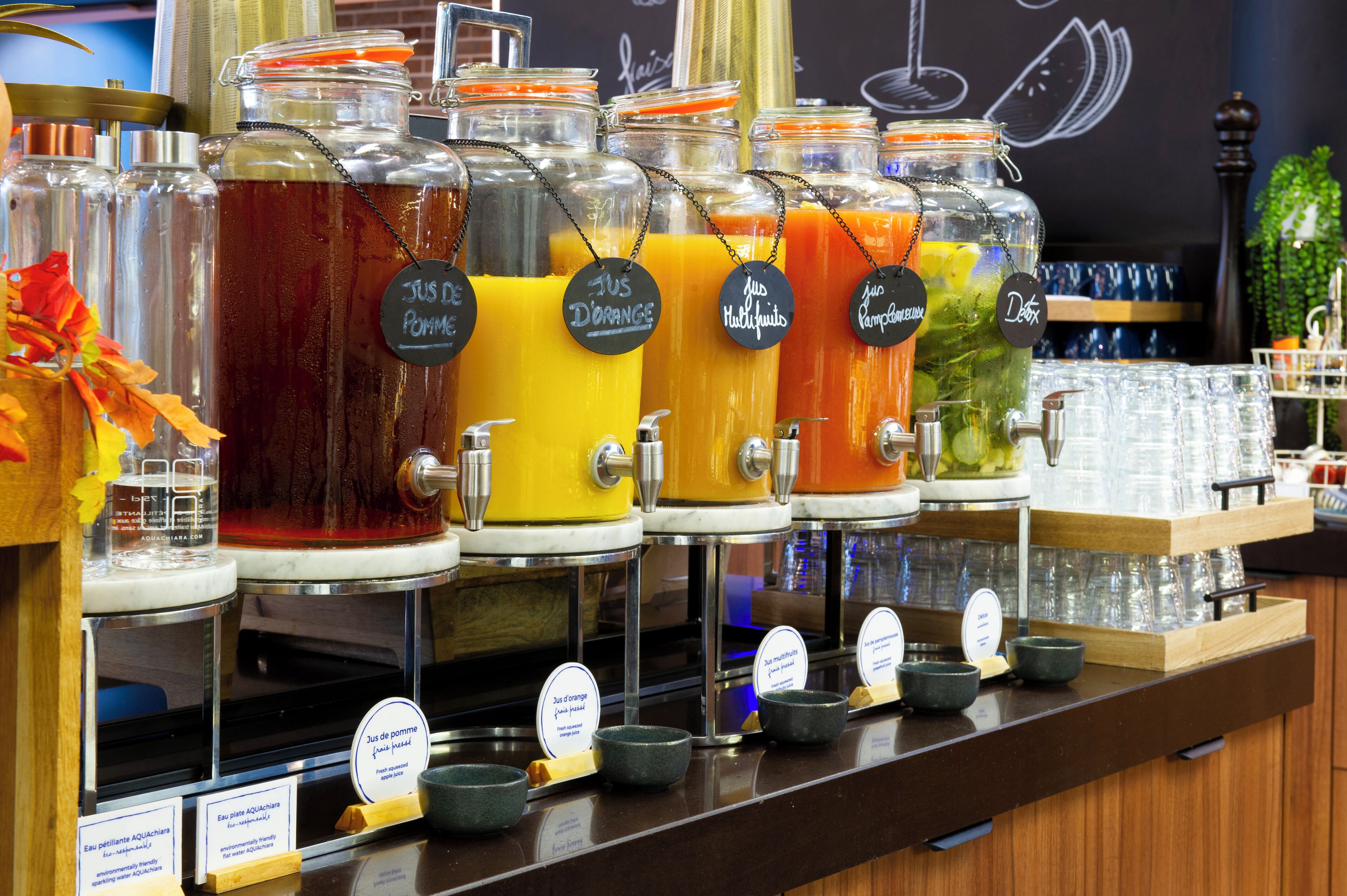 A beverage station with various drink dispensers labeled in French.