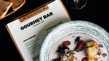 Un menu de restaurant avec une assiette de nourriture, des verres de vin et du pain.