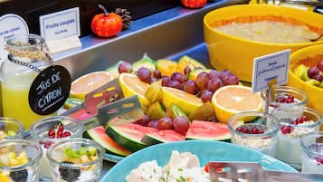 Ein Buffet mit verschiedenen Früchten, Suppenschalen und einem Schild, das frisch zubereitete Schalen anzeigt.