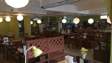 A restaurant with wooden furniture, a counter, and hanging lights.