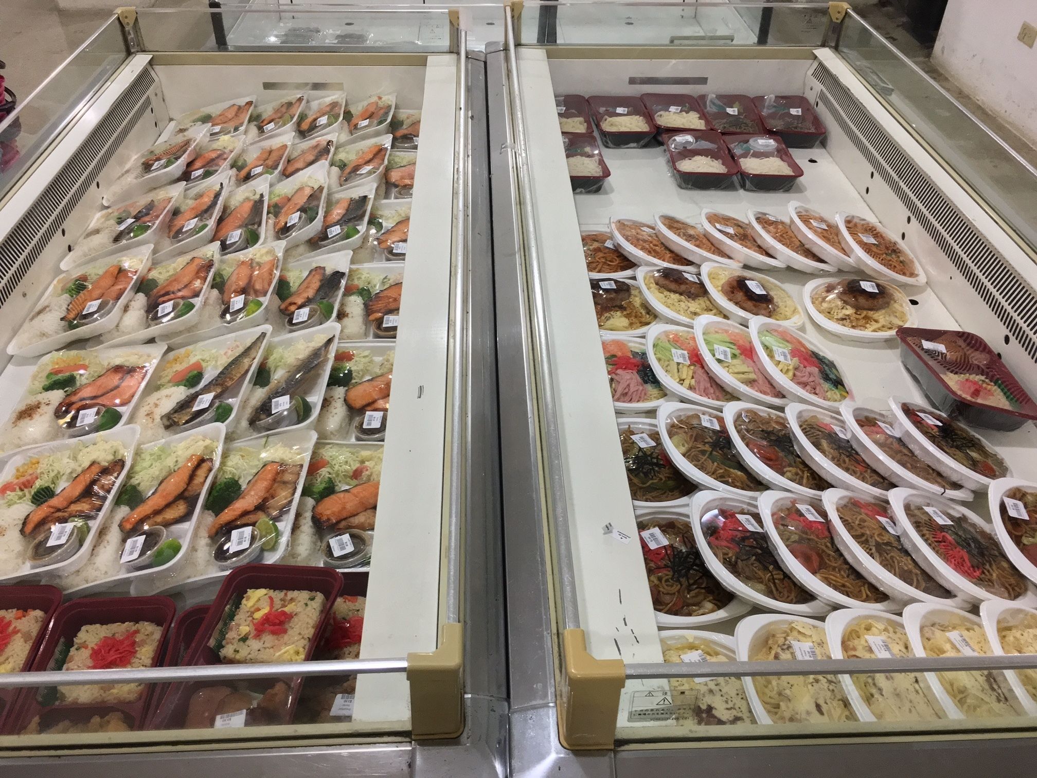 A refrigerated display case with various food items, including seafood and prepared meals.