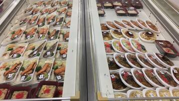 A refrigerated display case with various food items, including seafood and prepared meals.