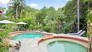 Una piscina al aire libre, sillones reclinables de piscina