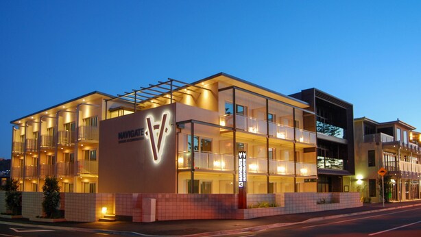 A multi-story hotel with a prominent 'Navigate' sign, balconies, and a modern architectural design.