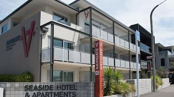 A multi-story hotel with balconies, a prominent 'Navigare' sign, and a sign for 'Seaside Hotel & Apartments'.
