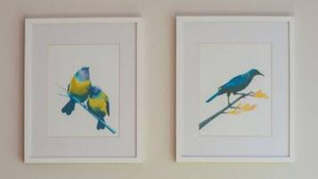 Two framed artworks of birds on branches.