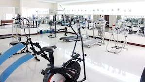 A gym with various exercise equipment, including treadmills and stationary bikes.